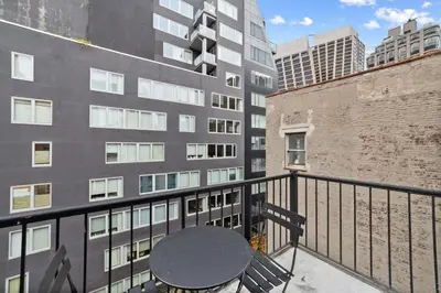 a balcony with a black table and a building at Chelsea Vista II by Rove Travel 2BR PH with Rooftop in New York