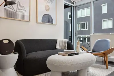 a living room with a black couch and a chair at Chelsea Vista II by Rove Travel 2BR PH with Rooftop in New York