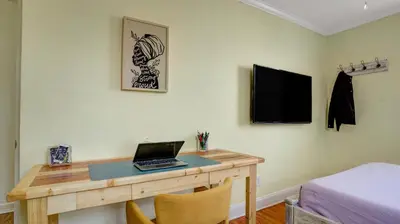 a desk with a laptop on it in a bedroom at Home Away From Home in Philadelphia