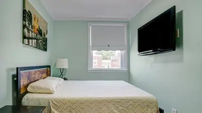 a bedroom with a bed and a flat screen tv at Home Away From Home in Philadelphia