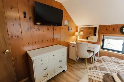 a bedroom with a bed and a desk and a tv on the wall at Arrowheadlake,videogames,fireplace,firepit,grill in Thornhurst
