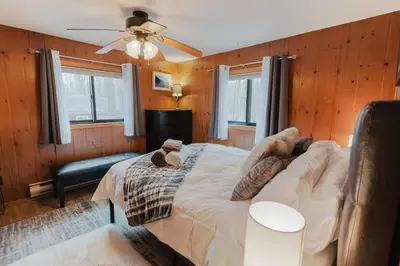 a bedroom with a bed and a ceiling fan at Arrowheadlake,videogames,fireplace,firepit,grill in Thornhurst