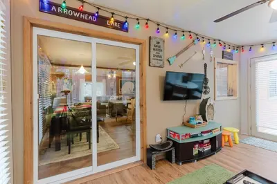 a living room with a sliding glass door and a dining room at Arrowheadlake,videogames,fireplace,firepit,grill in Thornhurst