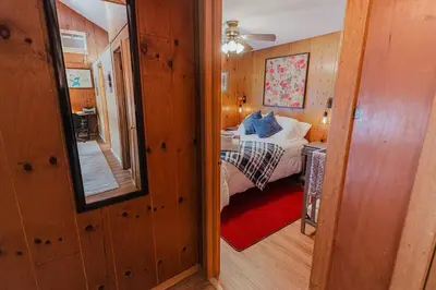 a small bedroom with a bed and a mirror at Arrowheadlake,videogames,fireplace,firepit,grill in Thornhurst