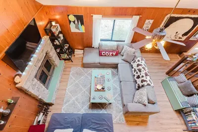 an overhead view of a living room with a couch at Arrowheadlake,videogames,fireplace,firepit,grill in Thornhurst