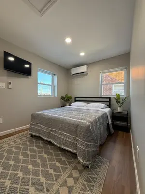 a bedroom with a bed and two windows at Cozy Cottage Flexible Stay in Wrightsville