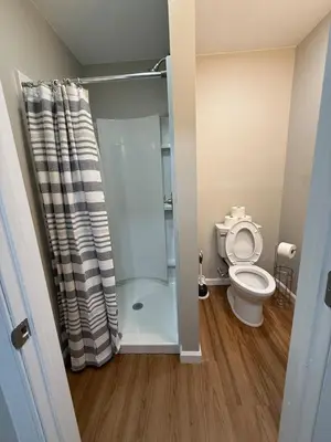 a bathroom with a shower and a toilet at Cozy Cottage Flexible Stay in Wrightsville