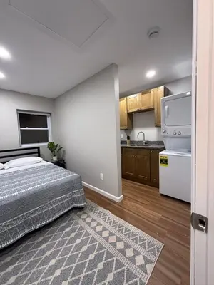 a bedroom with a bed and a kitchen at Cozy Cottage Flexible Stay in Wrightsville