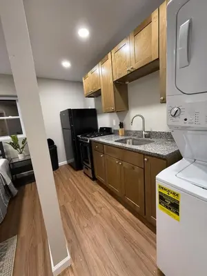 a kitchen with wooden cabinets and a white refrigerator at Cozy Cottage Flexible Stay in Wrightsville