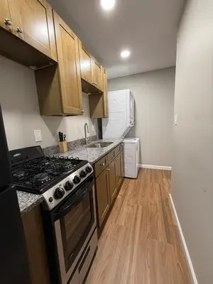 a kitchen with wooden cabinets and a stove top oven at Cozy Cottage Flexible Stay in Wrightsville