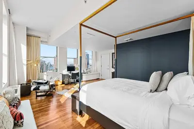 a bedroom with a large bed with a black accent wall at Broadway Terrace by Rove Loft with Private Terrace in New York