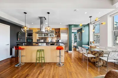a kitchen with a counter and a bar with stools at Broadway Terrace by Rove Loft with Private Terrace in New York