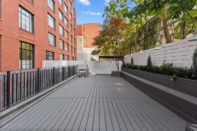 a wooden boardwalk in front of a brick building at Clinton by Rove Travel 3BR Duplex with Backyard in New York