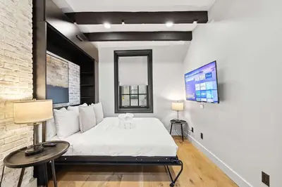 a bedroom with a white bed and a window at Downing by Rove Travel Private Terrace & Patio in New York