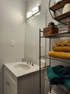a bathroom with a sink and a mirror and towels at Comfy, cozy, affordable and private - free parking in Richmond Valley