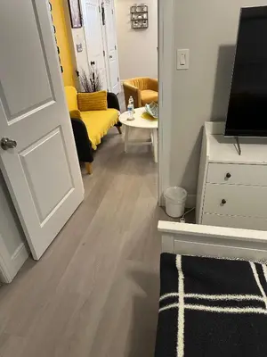 a hallway with a living room with a couch and a television at Comfy, cozy, affordable and private - free parking in Richmond Valley