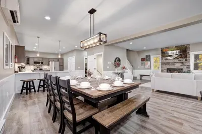 a dining room and living room with a table and chairs at New Luxury Lakeview Haven with Lake Access, HotTub, Game Room, Sleeps 26 in Lake Harmony