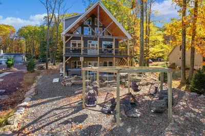 a house in the woods with a swing at New Luxury Lakeview Haven with Lake Access, HotTub, Game Room, Sleeps 26 in Lake Harmony
