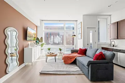 a living room with a couch and a kitchen at Modern 1BR Apartment Downtown Philly Near MET in Philadelphia