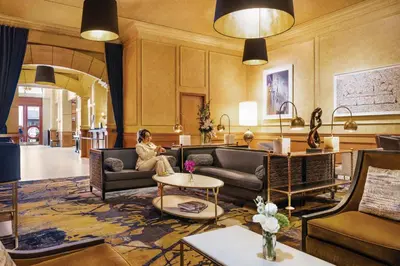 a woman sitting on a couch in a lobby at Executive Hotel Le Soleil New York in New York