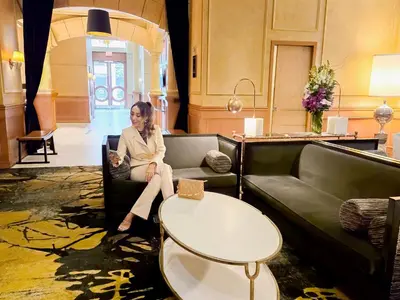 a woman sitting on a couch in a living room at Executive Hotel Le Soleil New York in New York