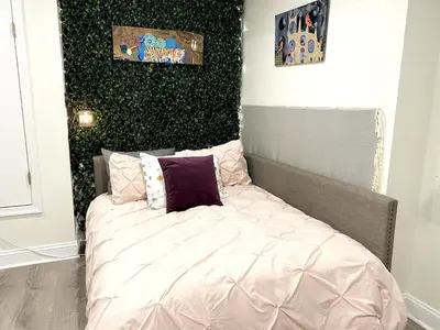 a bed with pink sheets and pillows in a room at Brand New Modern Flat, Heart of University City in Philadelphia