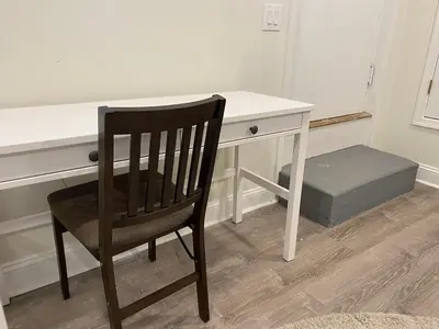 a chair sitting in front of a white desk at Brand New Modern Flat, Heart of University City in Philadelphia