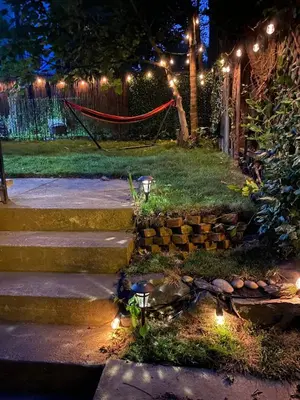 a garden at night with lights on the steps at Brand New Modern Flat, Heart of University City in Philadelphia