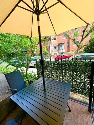 a picnic table with an umbrella and a chair at Brand New Modern Flat, Heart of University City in Philadelphia