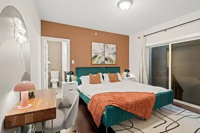 a bedroom with a green bed and a desk and a window at Luxury 3BR Rooftop Apartment Walk to MET and Metro in Philadelphia