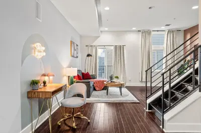 a living room with a staircase and a couch at Luxury 3BR Rooftop Apartment Walk to MET and Metro in Philadelphia