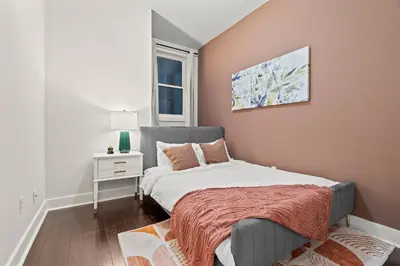 a small bedroom with a bed and a window at Luxury 3BR Rooftop Apartment Walk to MET and Metro in Philadelphia