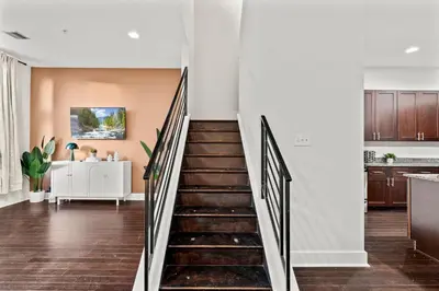a staircase in a home with white walls and wood floors at Luxury 3BR Rooftop Apartment Walk to MET and Metro in Philadelphia