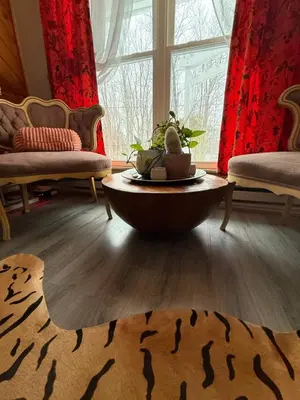 a living room with a large window and a table at Hillsaps Ranch on the Lake in Gouldsboro