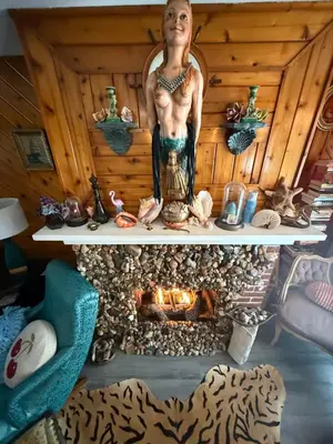 a statue of a man standing next to a fireplace at Hillsaps Ranch on the Lake in Gouldsboro
