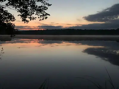 a view of a lake at sunset at Hillsaps Ranch on the Lake in Gouldsboro