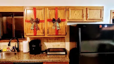 a kitchen with wooden cabinets with red bows on them at The CubHouse Poconos getaway in Tobyhanna