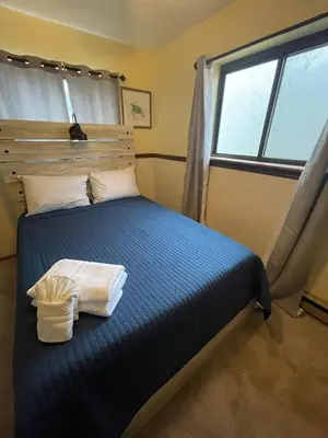 a bedroom with a large bed with a window at The CubHouse Poconos getaway in Tobyhanna