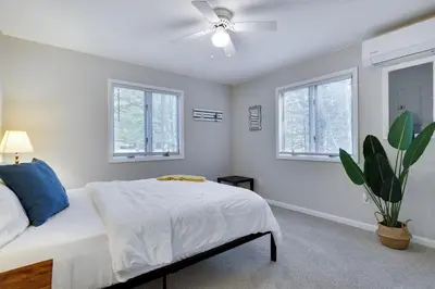 a white bedroom with a bed and a ceiling fan at Dreamy Lake House - Fireplace, Firepit & Pet Friendly in Pocono Lake