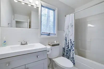 a bathroom with a sink and a toilet and a mirror at Dreamy Lake House - Fireplace, Firepit & Pet Friendly in Pocono Lake
