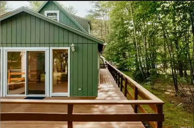 a green house with a wooden walkway leading to it at Charming, Pet-friendly Lake front Retreat WiFi in Ferndale