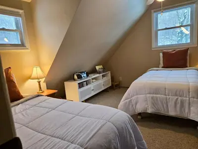 a attic bedroom with two beds and a window at Charming, Pet-friendly Lake front Retreat WiFi in Ferndale