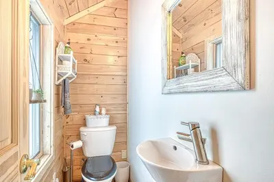 a bathroom with a toilet and a sink and a mirror at In the clouds your cozy- lake house in Swan Lake