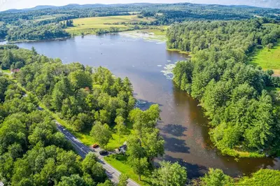 an aerial view of a river with trees at In the clouds your cozy- lake house in Swan Lake