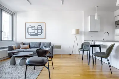 a living room with a couch and a table and chairs at Hells Kitchen 1BR w Doorman nr Central Park NYC-521 in New York