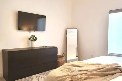 a bedroom with a dresser with a television on the wall at Modern Living in PHX Heated Pool Arizona Charm in Philadelphia