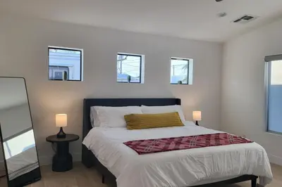 a bedroom with a bed with two lamps and two windows at Modern Living in PHX Heated Pool Arizona Charm in Philadelphia
