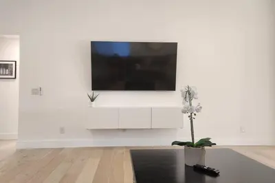 a white living room with a tv on a white wall at Modern Living in PHX Heated Pool Arizona Charm in Philadelphia