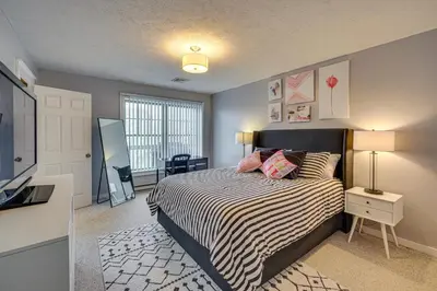 a bedroom with a bed with a striped bedspread at Spacious Modern Home about 1 Mi to Camelback Mountain! in Tannersville