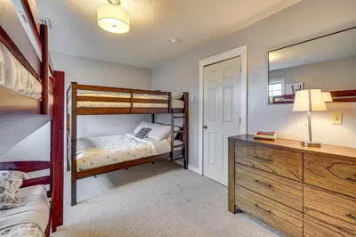 a bedroom with bunk beds and a dresser with a mirror at Spacious Modern Home about 1 Mi to Camelback Mountain! in Tannersville